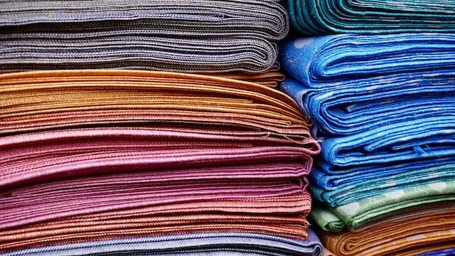 A stack of freshly dyed polyester and nylon fabrics in all colors.